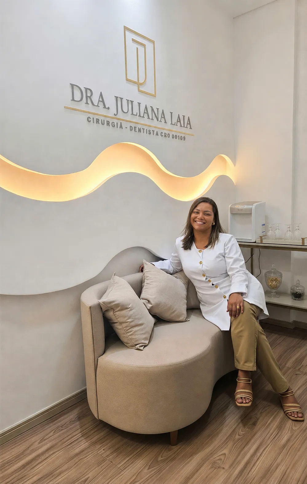 Dra. Juliana Laia, cirurgiã-dentista, sentada na recepção do consultório no Barreiro, em Belo Horizonte