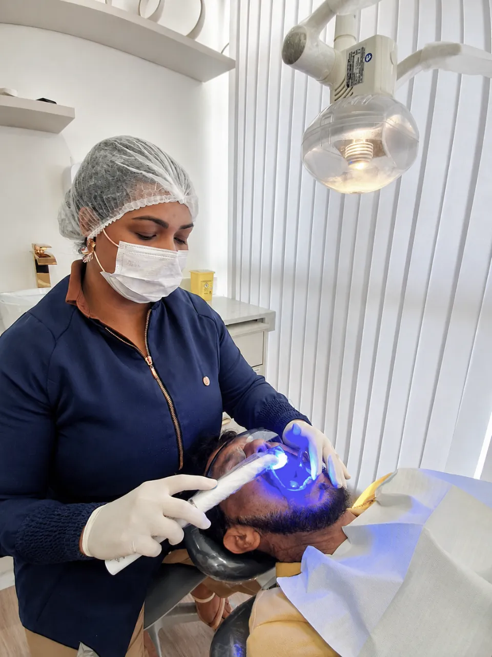 Aplicação de clareamento dental com luz de LED durante o atendimento
